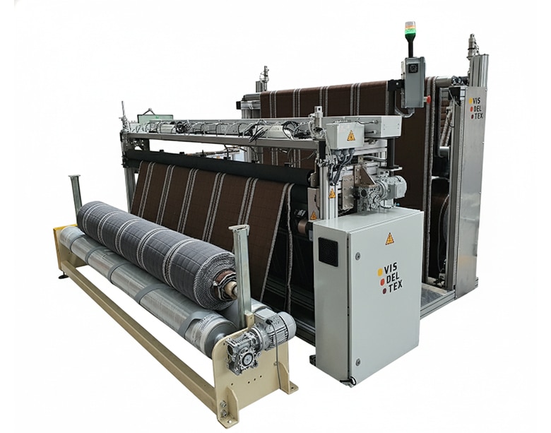 Vista frontal de la máquina industrial Modelo VU CMP, especializada en el corte por ultrasonidos de platabandas y bordes de colchón, mostrando el área de control y entrada/salida de material.