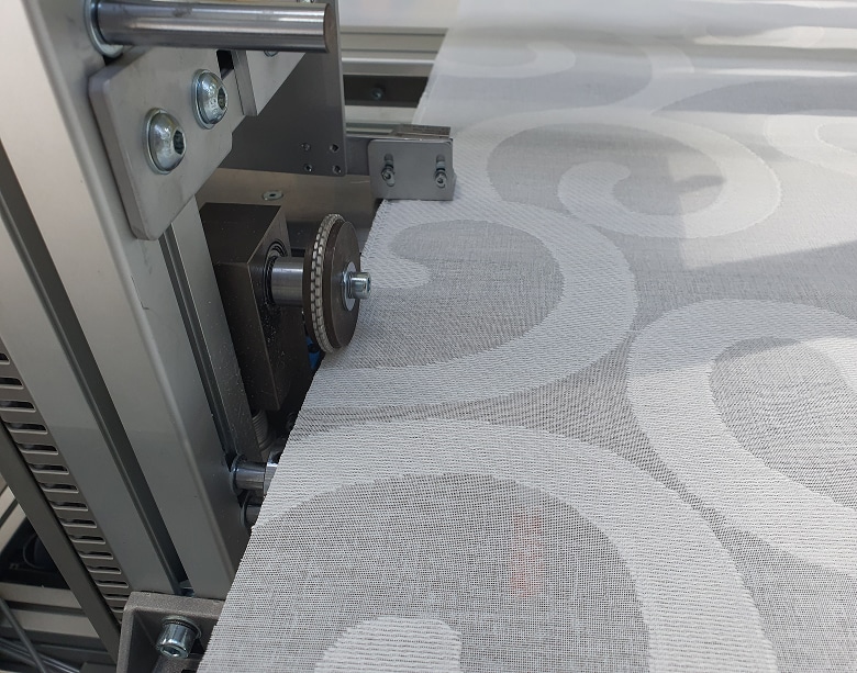 Vista de la estación de confección, mostrando los mecanismos de sellado por ultrasonidos que unen el fleje superior al dobladillo de la cortina técnica sin necesidad de hilo.